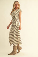 woman wearing a striped midi dress with a tie waist and cap sleeves, paired with beige knee-high boots