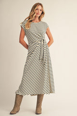 woman wearing a cream and black striped midi dress with a side tie and slit, paired with brown knee-high boots