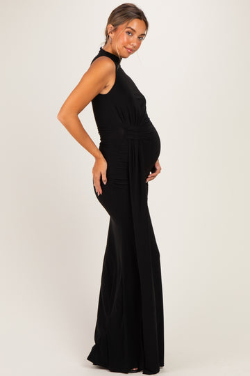 woman wearing a black sleeveless maternity dress with side ruching and showing her baby bump