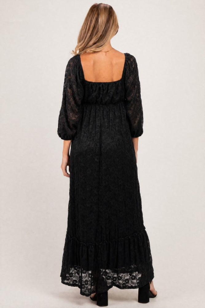 woman wearing a black lace maternity maxi dress with puff sleeves and a ruffled hem