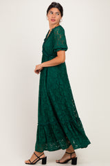 woman wearing a green lace maxi dress with short sleeves and a tiered skirt, styled with black heeled sandals