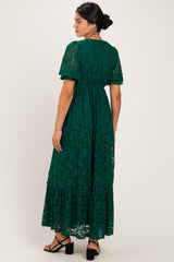 woman wearing a dark green lace maxi dress with short sleeves and a tiered hem, shown from the back