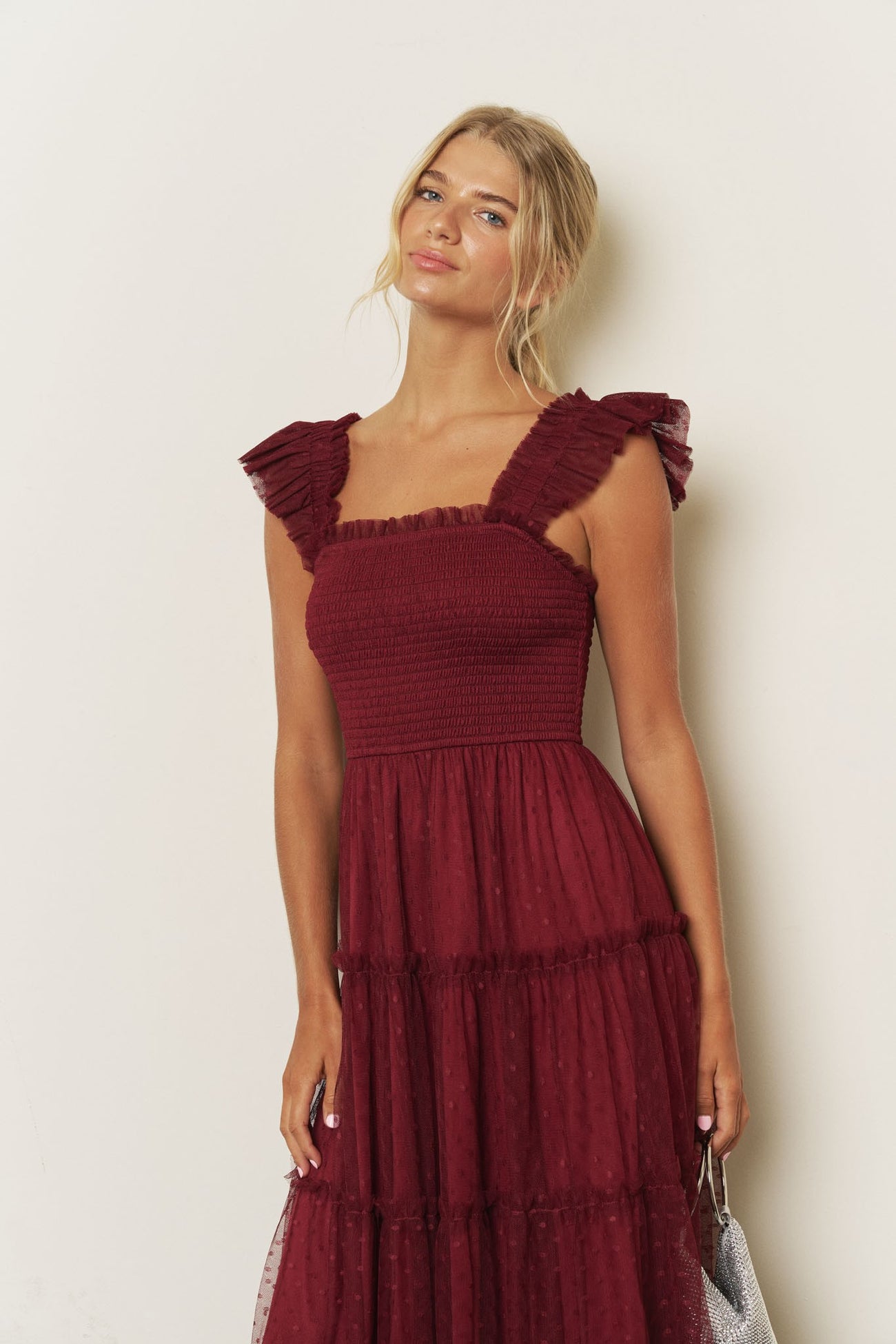 woman wearing a burgundy smocked sundress with ruffle straps and tiered skirt