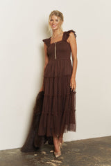 woman wearing a brown tiered maxi dress with ruffle straps and a fitted bodice, accessorized with a long necklace