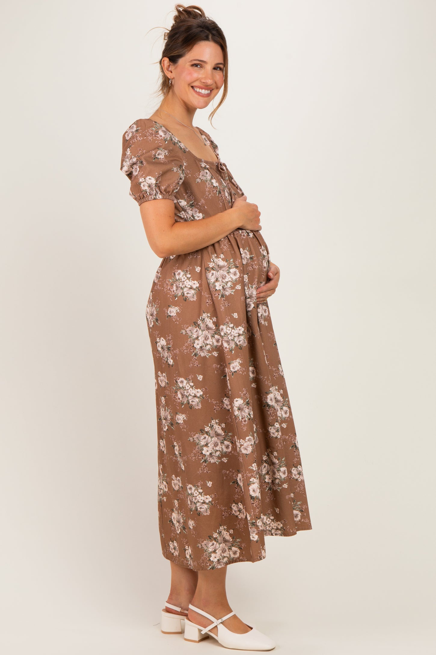woman wearing a brown floral maternity dress with a flowy silhouette and baby bump visible
