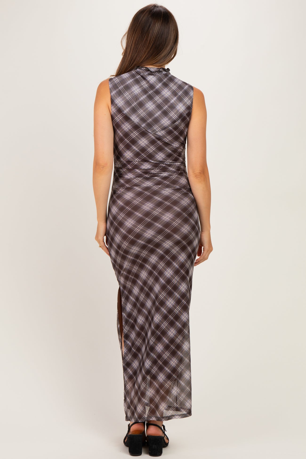 woman wearing a brown plaid maternity maxi dress with a high slit, showing a pregnant baby bump from the back