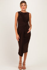 woman wearing a brown maternity dress with a knot detail at the waist, gently cradling her baby bump