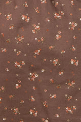 brown maternity wear fabric with small floral patterns in shades of pink, orange, and white