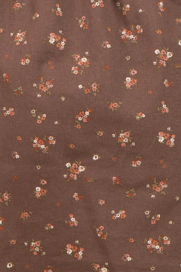 brown maternity wear fabric with small floral patterns in shades of pink, orange, and white