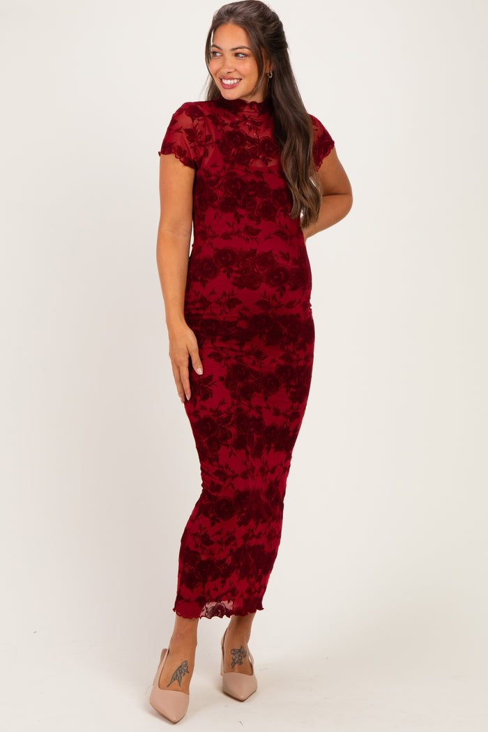 woman wearing a burgundy floral lace maternity dress that hugs her curves and showcases her baby bump