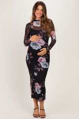woman wearing a black floral long sleeve maternity dress and holding her baby bump