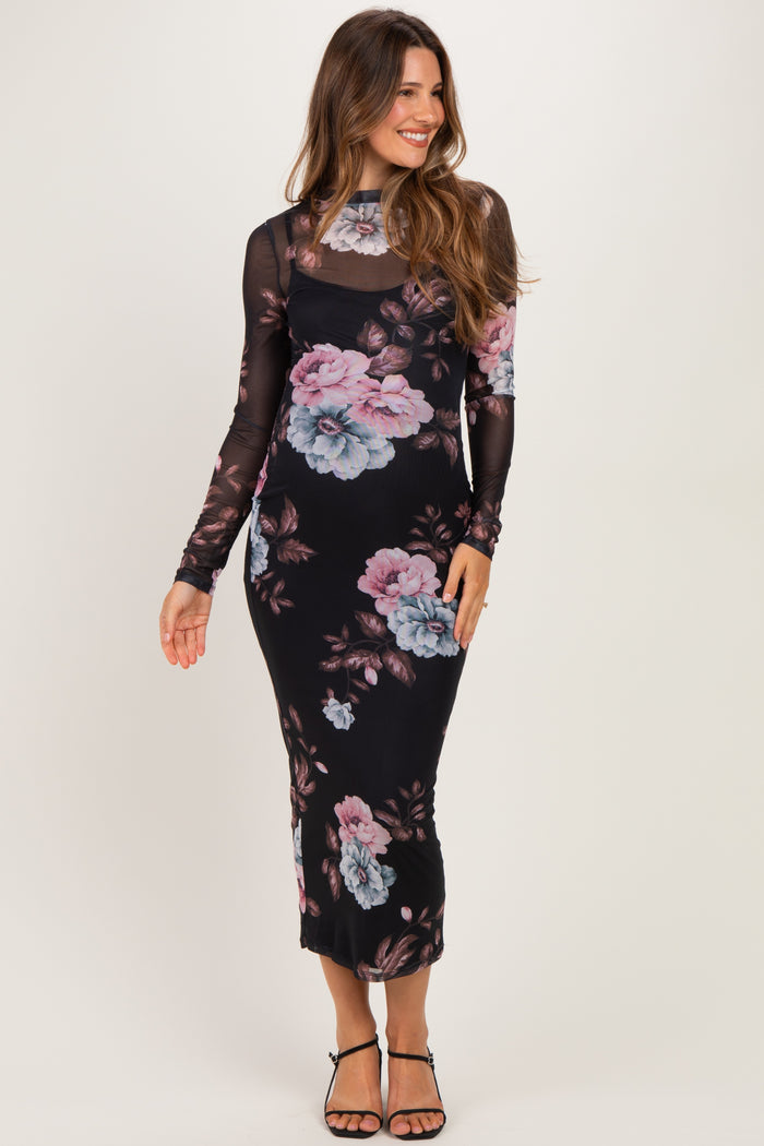woman wearing a black floral maternity dress with long sleeves and a fitted silhouette