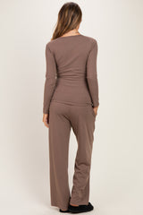 woman wearing a brown long sleeve maternity top and matching pants, viewed from the back
