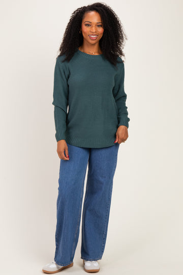 woman wearing a dark green textured long sleeve sweater and wide leg denim jeans