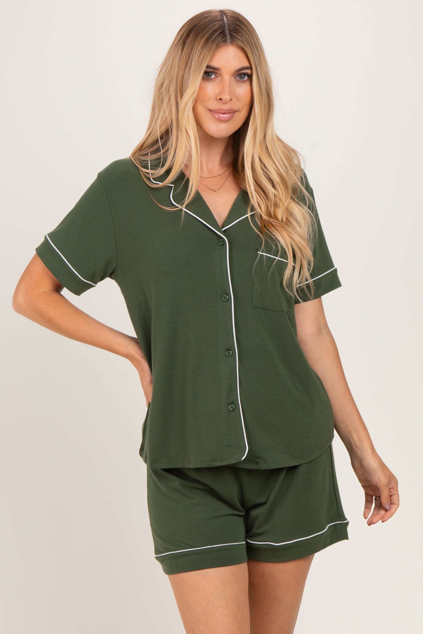 woman wearing a green short sleeve pajama set with white piping