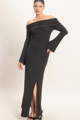 woman wearing a black off-the-shoulder ribbed maxi dress with long sleeves and a side slit