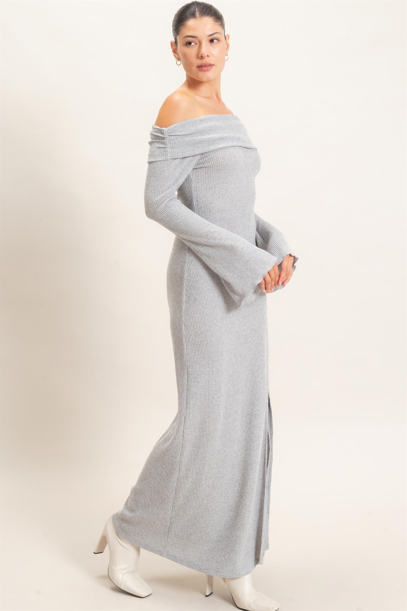 woman wearing a grey off-the-shoulder ribbed maxi dress with bell sleeves and a side slit