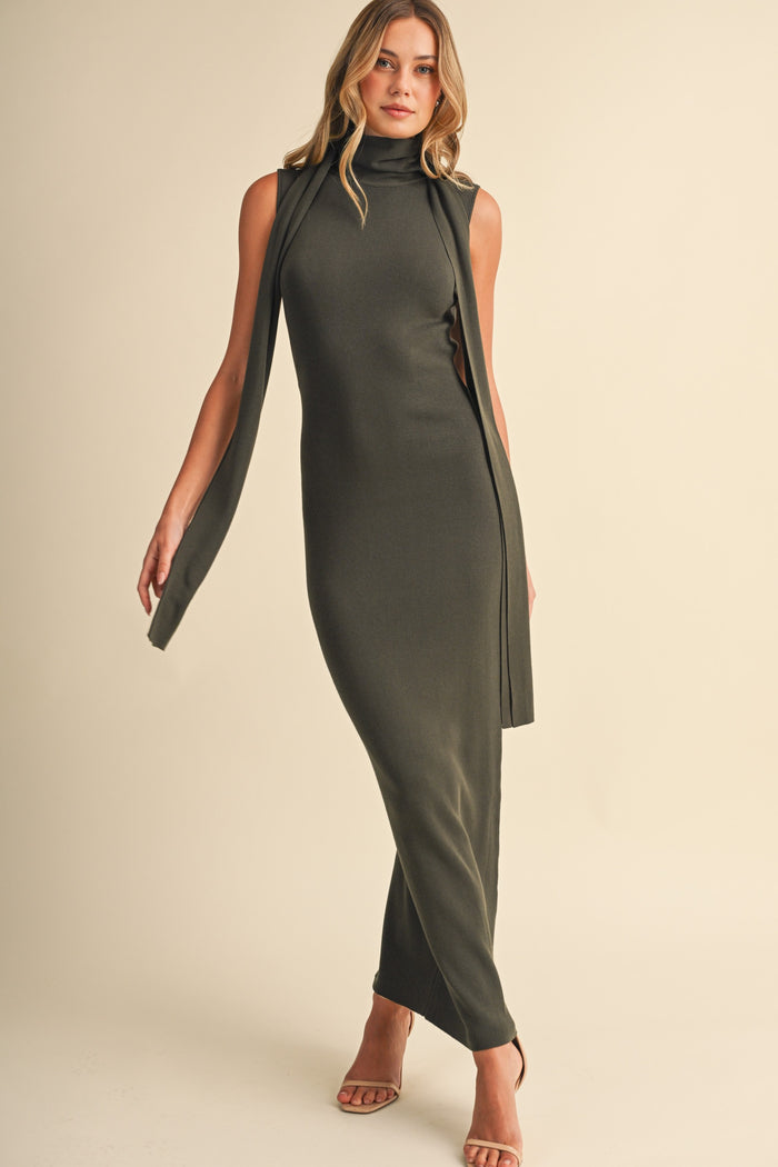 woman wearing a dark green sleeveless maxi dress with side slits and a high neckline