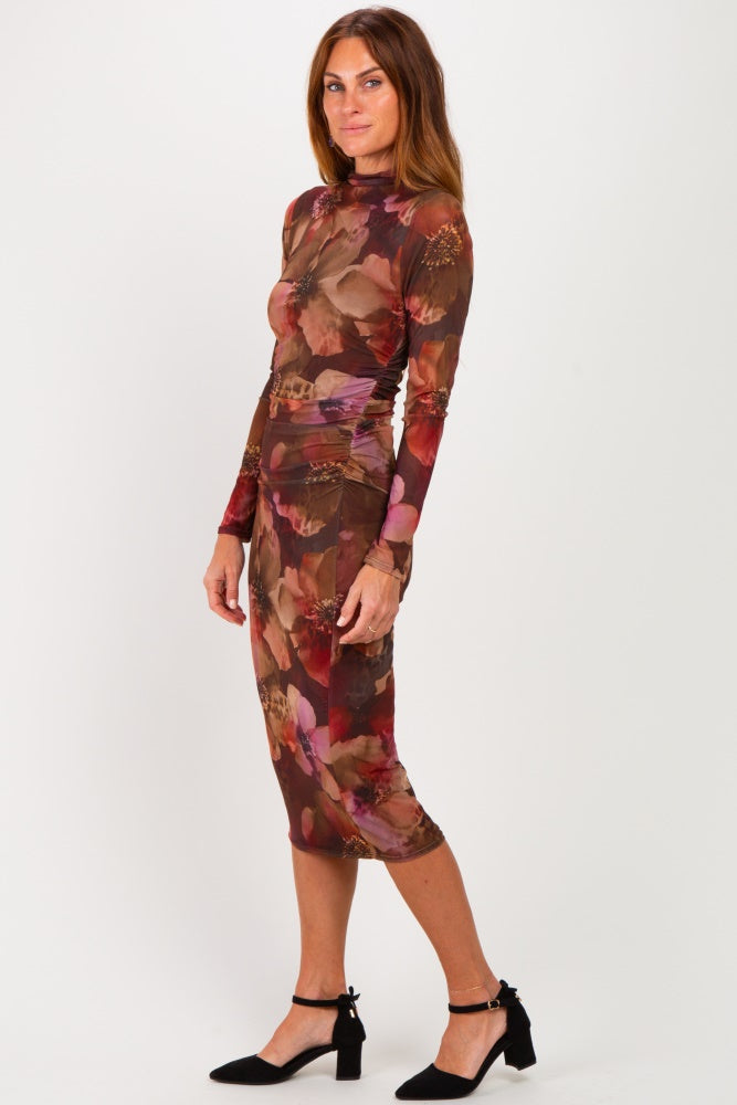 woman wearing a fitted long sleeve brown floral midi dress with a high neckline and black block heel shoes
