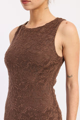 woman wearing a brown sleeveless dress with textured floral detailing