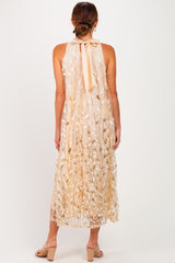 woman wearing a beige floral maxi dress with a halter neck and a bow detail at the back