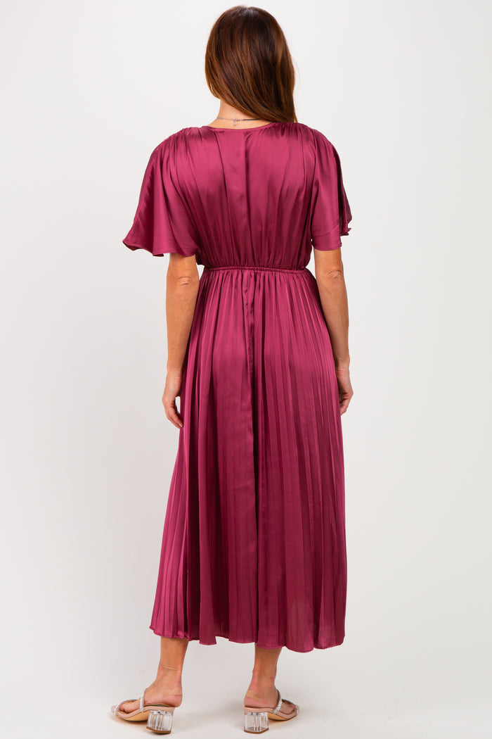 woman wearing a burgundy pleated midi dress with flutter sleeves, viewed from the back