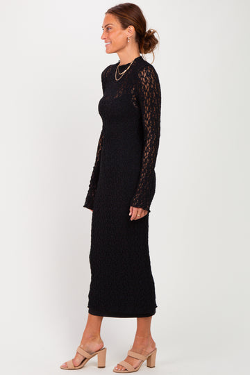 woman wearing a black long sleeve lace midi dress and beige heeled sandals