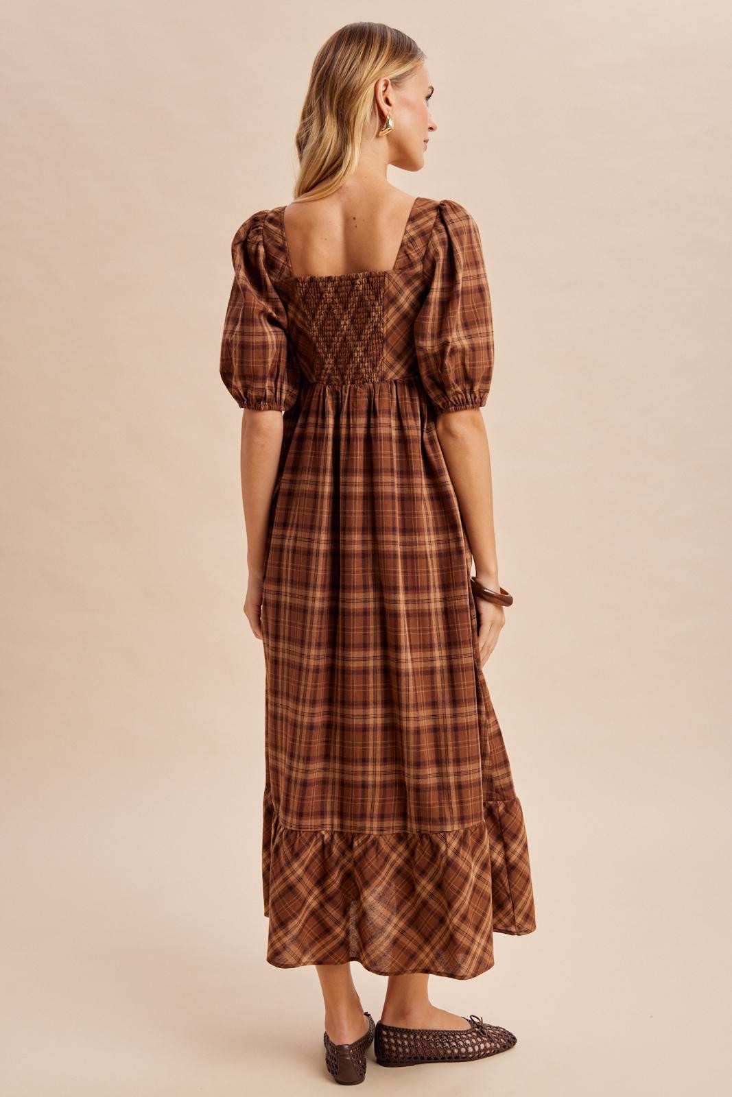 woman wearing a brown plaid long sleeve maxi dress with puffed sleeves and a smocked back detail