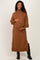 woman wearing a brown maternity sweater dress with a tie waist and a visible baby bump