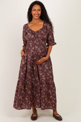 woman wearing a brown floral maternity maxi dress with puff sleeves and a baby bump visible