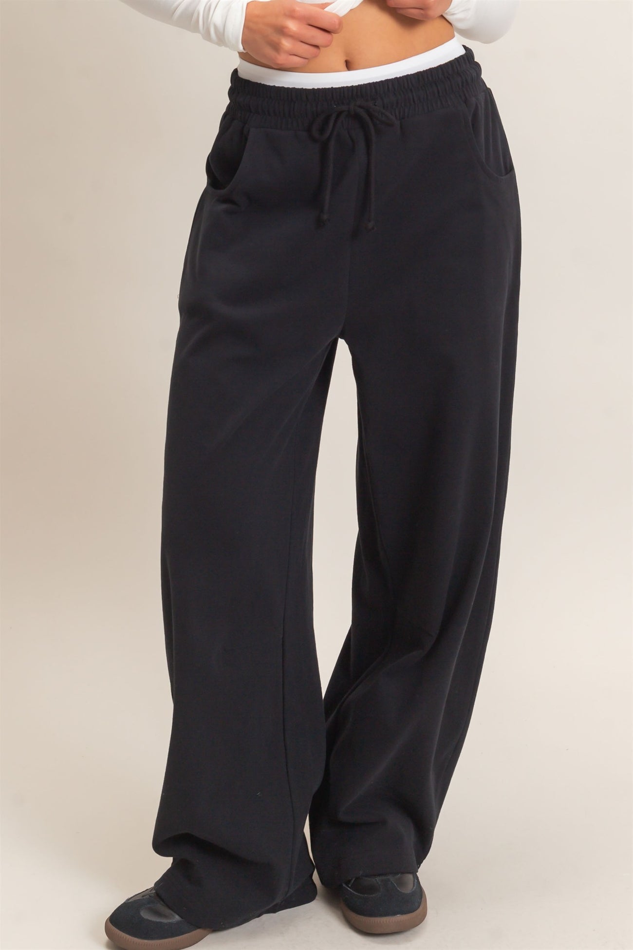 woman wearing black wide-leg lounge pants with an elastic waistband and side pockets