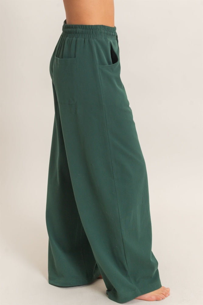 woman wearing green wide-leg pants with an elastic waistband and side pockets