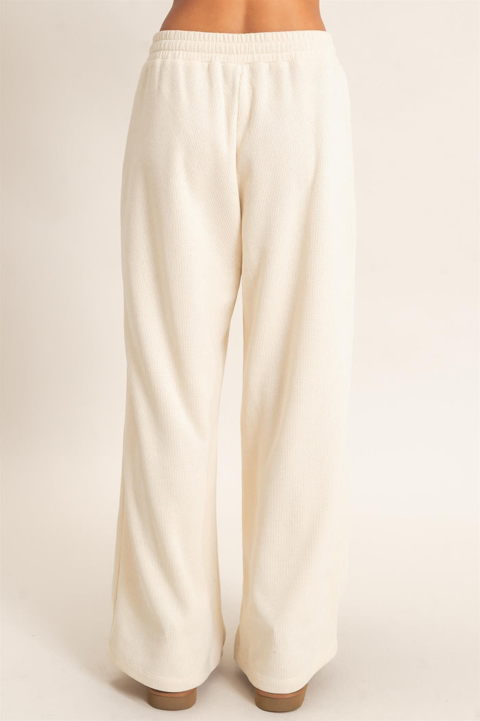 woman wearing cream wide-leg lounge pants with an elastic waistband