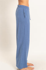 woman wearing blue wide-leg lounge pants with an elastic waistband and drawstring detail