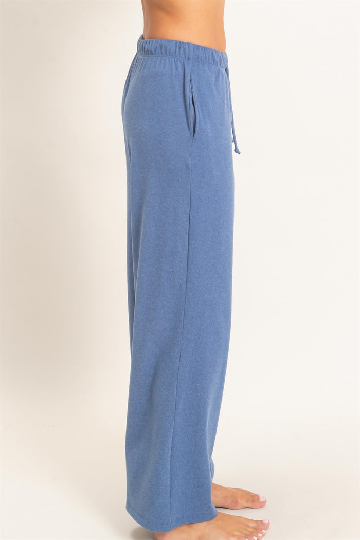 woman wearing blue wide-leg lounge pants with an elastic waistband and drawstring detail