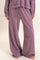 woman wearing purple wide leg lounge pants with a drawstring waist and a relaxed fit