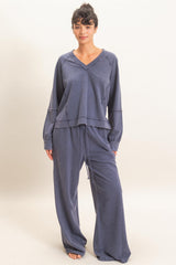 woman wearing a navy blue loungewear set with a v-neck long sleeve top and wide leg pants