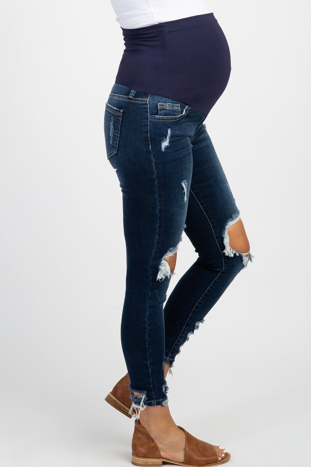 woman wearing a black maternity t-shirt with white text and distressed denim jeans, showing her baby bump