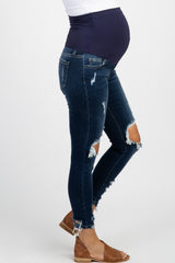 woman wearing a black maternity t-shirt with white text and distressed denim jeans, showing her baby bump