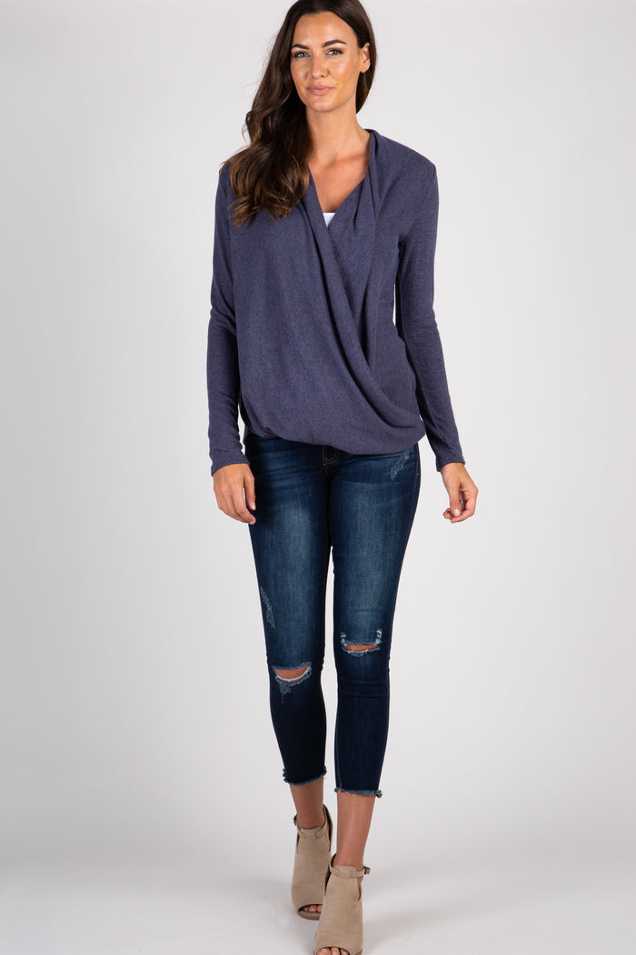 woman wearing a purple long sleeve draped front top and distressed blue skinny jeans