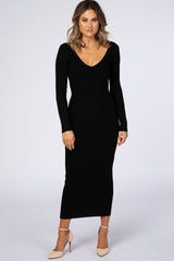 woman wearing a fitted black ribbed long sleeve maxi dress with a plunging neckline