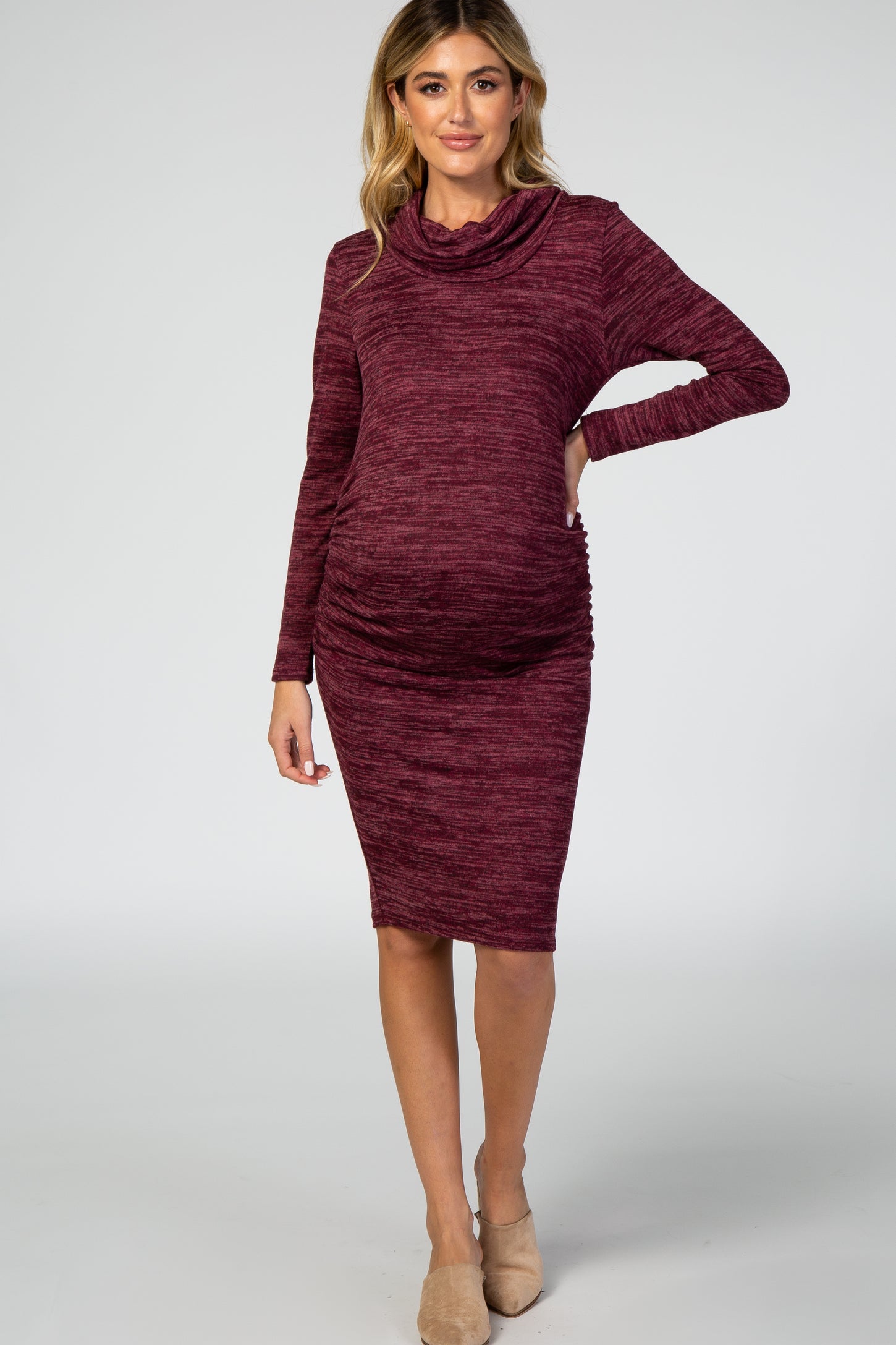 woman wearing a burgundy long sleeve maternity dress with a cowl neck and side ruching, showcasing her baby bump