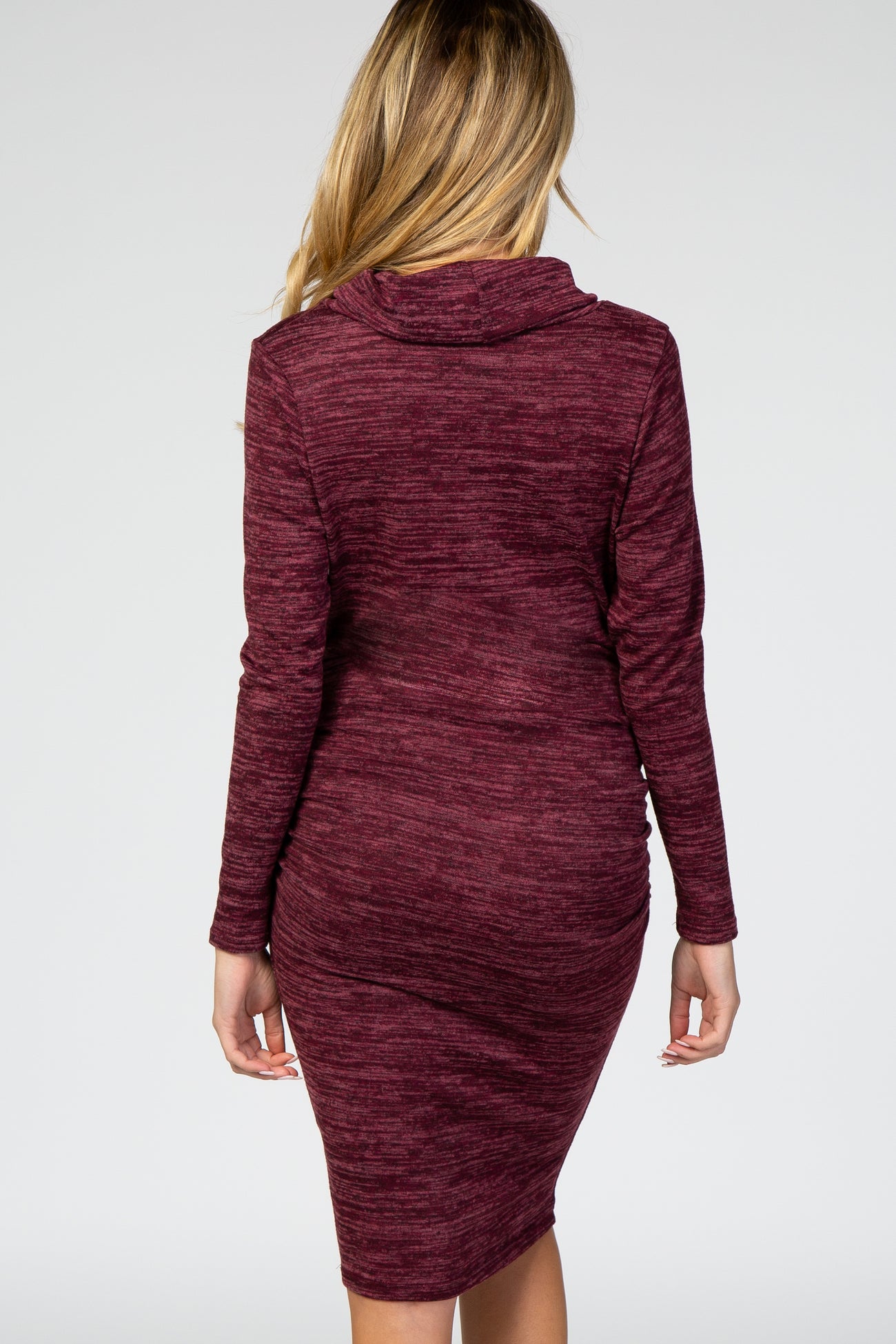 woman wearing a burgundy maternity dress with a fitted silhouette and cowl neck, showing a pregnant belly from the back