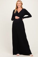 woman wearing a black long sleeve maternity dress and showing her baby bump