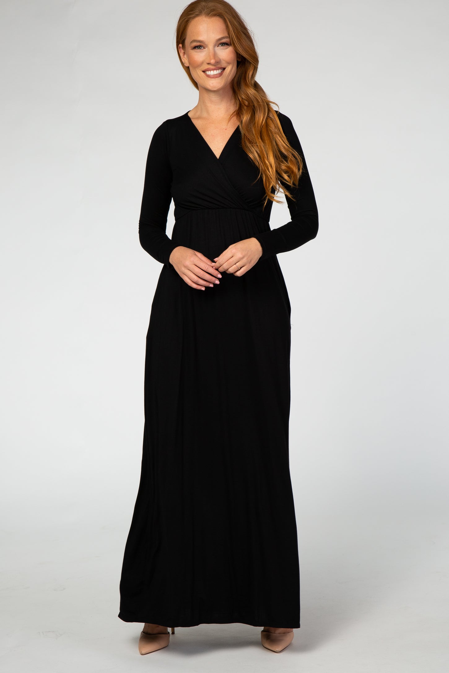 woman wearing a black long sleeve maxi dress with a wrap bodice and pockets