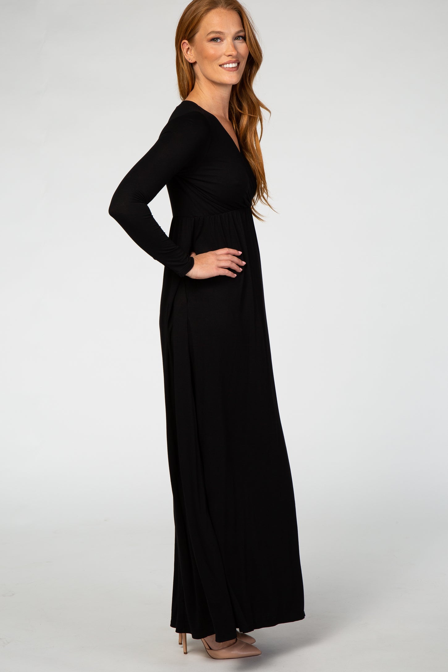 woman wearing a flattering black long sleeve maxi dress with a fitted bodice and flowing skirt