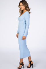woman wearing a light blue ribbed long sleeve midi dress and black strappy heels