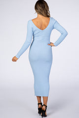 woman wearing a light blue ribbed midi dress with a deep v-back and long sleeves, showing a fitted silhouette