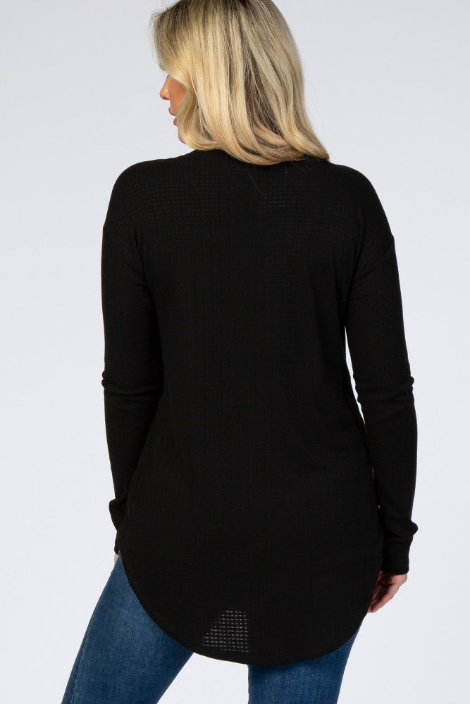 woman wearing a black long sleeve maternity top with a curved hem and a relaxed fit, viewed from the back
