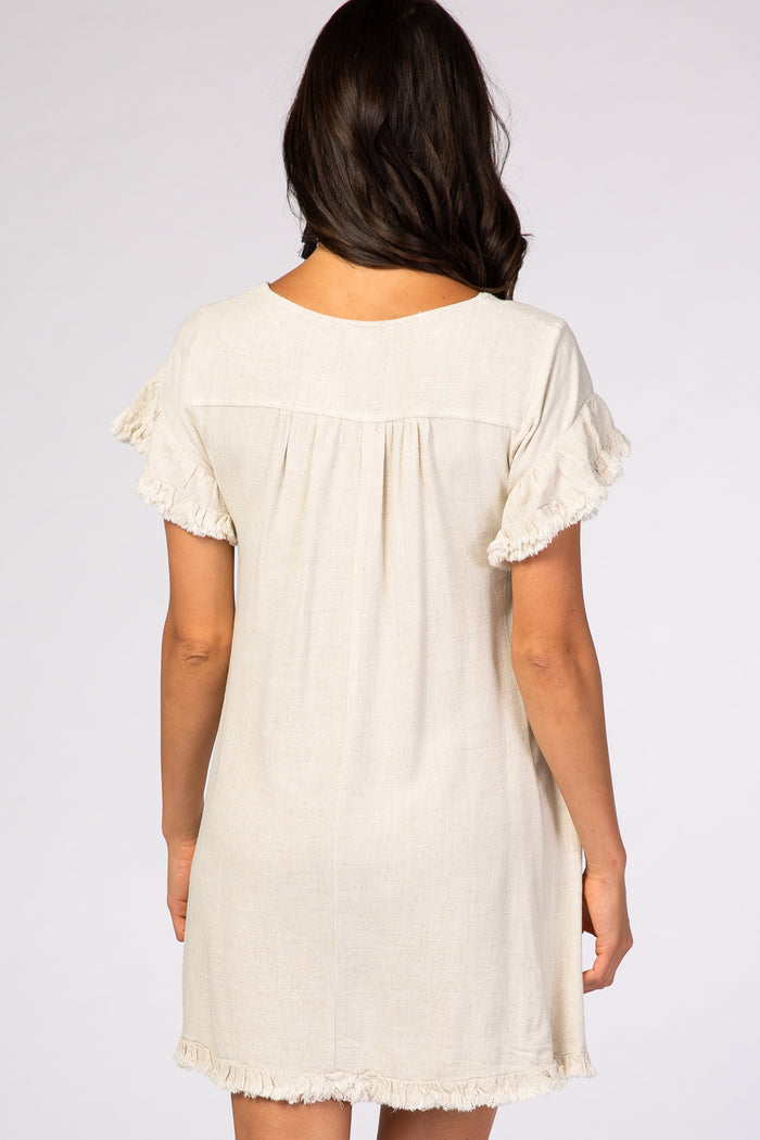 woman wearing a beige short-sleeve linen dress with ruffled sleeves and a relaxed fit from the back